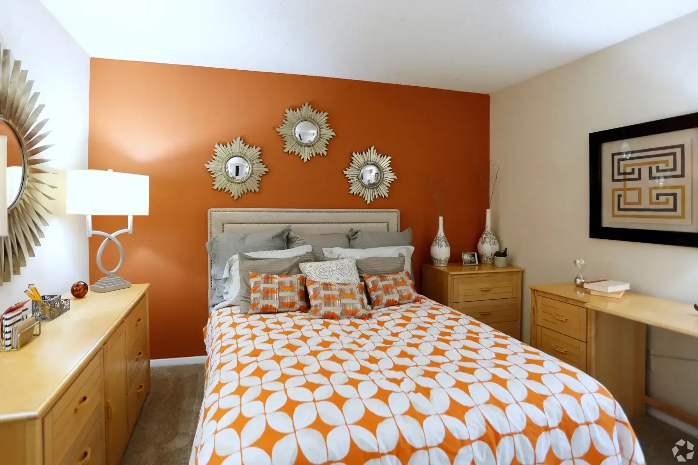Bright apartment bedroom with patterned bedding and storage furniture at Norcross Crossings