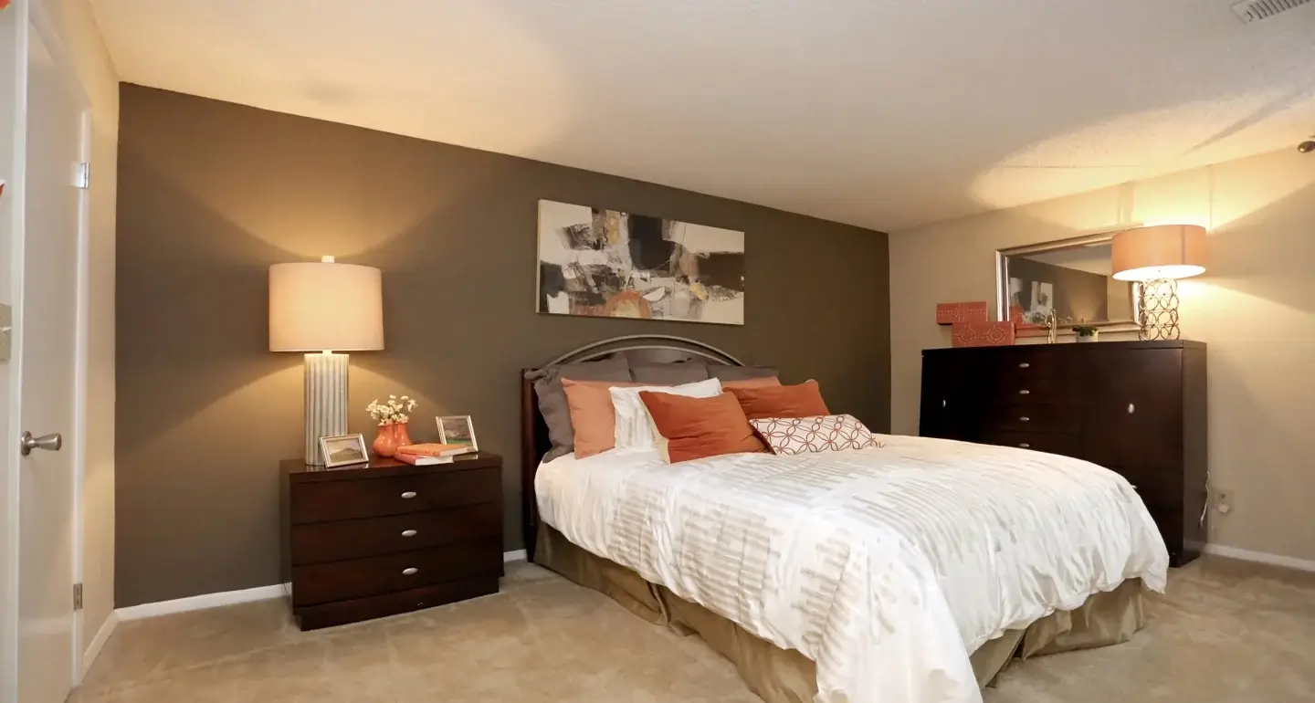 Spacious Norcross Crossings apartment bedroom with dresser and bedside lighting